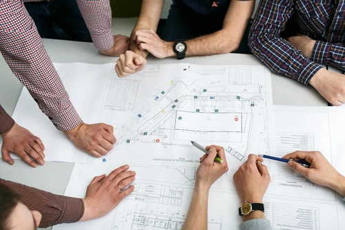 Team von Putz & Pracht beim Besprechen eines Bauplans auf der Baustelle